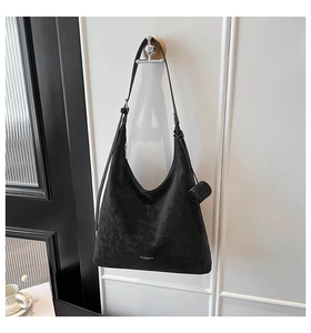 Detailed view of black suede hobo tote with MALUVI BAGS logo and hanging accessory