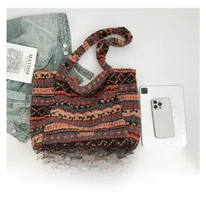 Close-up of ethnic wave pattern plush tote bag with leather label and soft wool texture