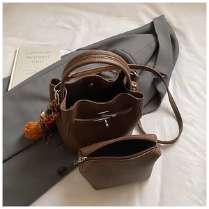 Detail view of brown lychee grain bucket bag set with mini pouch and plush charm