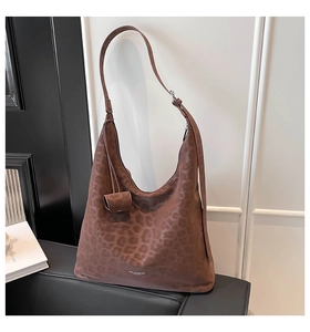 Detail of vintage leopard print tote bag in brown suede with adjustable strap and charm
