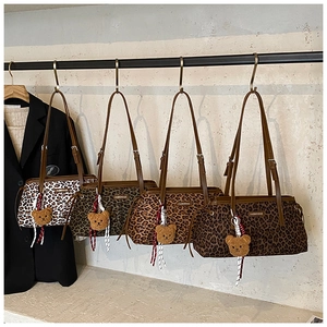 Détail de quatre sacs portés épaule imprimé léopard avec breloque ours en rayon