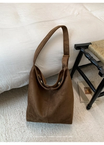 Detailed view of brown matte suede hobo bag with wide shoulder strap and metal zipper