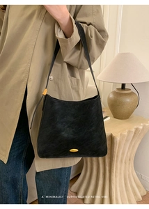 Minimalist black retro shoulder bag with golden metal buckle styled on a trench coat