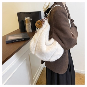 Détail du sac hobo en peluche blanche avec pompon marron et nœud à imprimé léopard