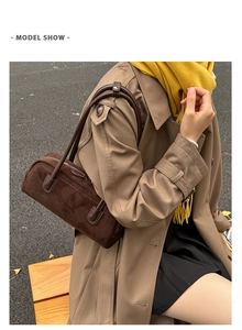Brown suede shoulder bag shown on model with camel trench coat in outdoor street setting