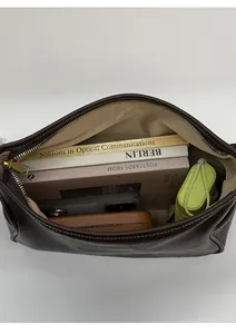 Top view of large capacity dark brown leather tote interior with golden zipper and items