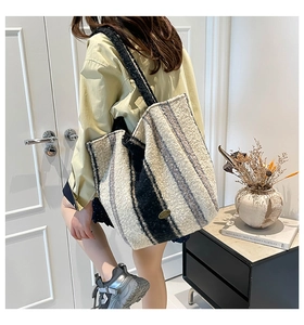 Detailed back view of a plush striped tote bag featuring faux fur and metal logo detail
