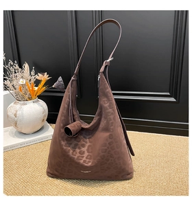 Close-up of leopard pattern tote bag with gold brand logo and leather shoulder strap