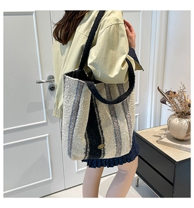 Fuzzy patchwork tote bag in neutral tones styled over the shoulder for a winter outfit