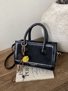 Schwarze Vintage Handtasche aus Mattleder mit Holzperlen-Quaste auf Holztisch