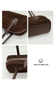 Detail of dark brown suede Boston bag featuring silver zippers and reinforced stitching