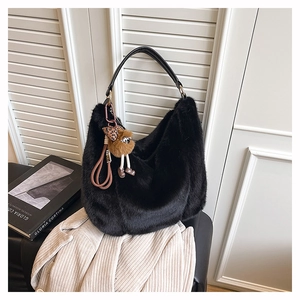 Détail du sac cabas en fausse fourrure noire avec pendentif et poignée élégante