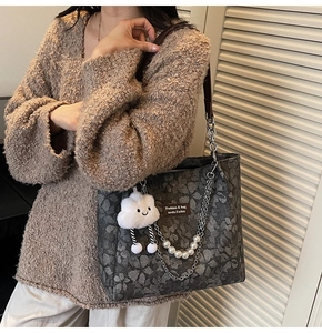 Detail of dark grey floral canvas tote with pearl chain and cute plush cloud charm