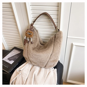 Gros plan sur un sac cabas en fausse fourrure marron avec un pendentif chat léopard chic