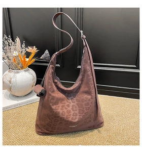 Detail view of large mauve leopard print hobo bag with a matching coin purse charm