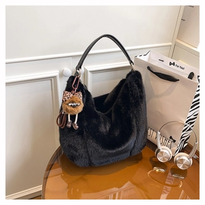 Détail du sac cabas en fausse fourrure noire avec breloque peluche et bandoulière cuir