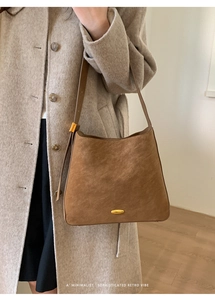 Detail showing high-end golden metal hardware and suede texture of retro brown bucket bag