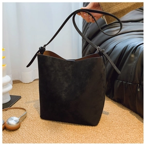 Detailed view of the black matte suede bucket bag with long strap and large capacity