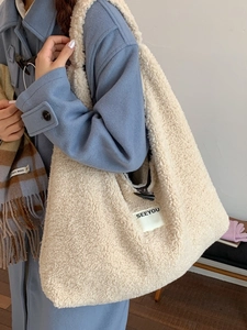 Chic beige faux fur shoulder bag with horn toggle and SEEYOU tag worn with blue coat