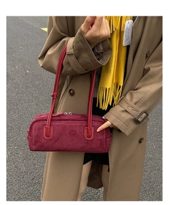 Detail of red suede Boston handbag with silver zipper and white stitching accents