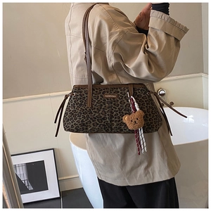 Détail du sac léopard avec bandoulière en cuir marron et breloque petit ourson