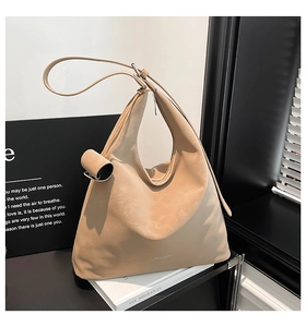 Detail of beige textured leather tote bag featuring a minimalist logo and chic urban style