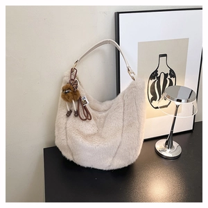 Détail du sac hobo en fausse fourrure beige avec bandoulière et breloque en peluche léopard