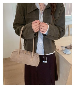 Detail of light khaki suede Boston bag featuring double handles and smooth dual zippers