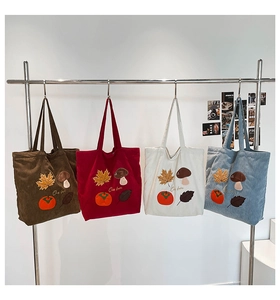 Détail de broderie de feuilles d'automne et champignons sur sacs en velours
