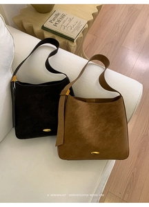 Detail view of retro black and tan shoulder bags on a cozy sofa setting
