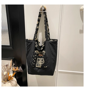 Detail of contrast stitch tote with faux shearling trim and plush front pocket detail