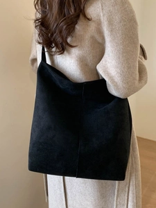 Large black faux suede tote bag shown on model with minimalist autumn winter shoulder style