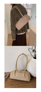 Detail of beige suede Boston bag featuring long leather shoulder straps and zipper