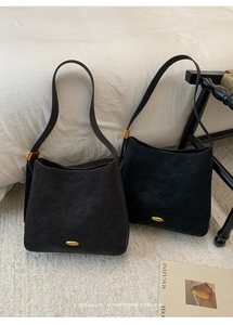 Detail view of retro bucket bags in black and brown with elegant gold metal hardware