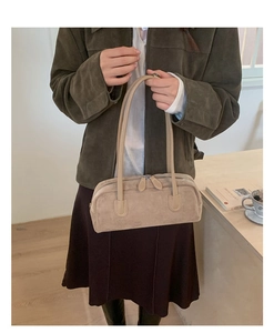 Close-up of beige suede shoulder bag with thin straps and dual leather zippers detail