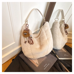 Détail du sac hobo en peluche blanc cassé avec breloque léopard et texture fausse fourrure