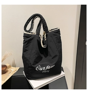Close-up of black fabric tote bag with white Our fave Party print and patterned lining