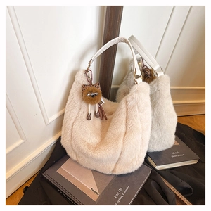 Détail du sac hobo en peluche beige avec bandoulière en cuir et breloque chouette