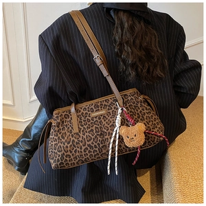 Détail du sac fourre-tout léopard avec logo métallique et breloque ours en peluche