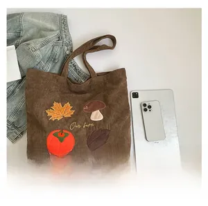 Détail de la broderie d'automne avec feuilles d'érable et champignons sur cabas en velours