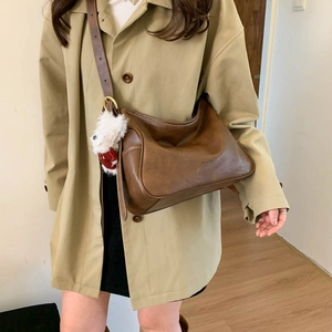 Retro brown leather hobo bag with adjustable strap and cute white plush toy charm accessory