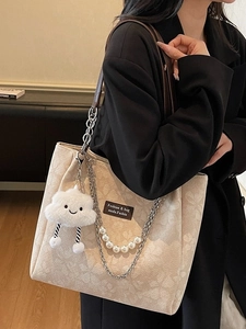 Beige floral embossed tote bag with silver chains, pearls and cloud charm on model
