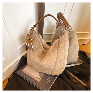 Détail du sac hobo en peluche camel avec bandoulière en cuir et breloque monstre