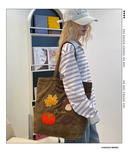 Détails de broderie de feuilles d'érable et de champignons sur un sac cabas en velours