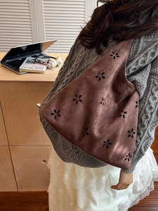 Retro brown suede tote bag with laser-cut floral patterns shown in a lifestyle setting