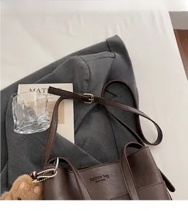 Close-up of brown leather bag with fashion bag engraving and cute teddy bear charm