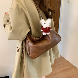 Brown moon bag with white stitching detail and a cute plush puppy charm for women