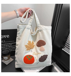 Détail de la broderie d'automne avec champignons et feuilles d'érable sur cabas en velours