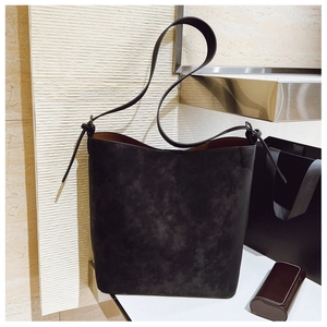 Detail view of the black retro shoulder bucket bag featuring soft matte texture and knot strap