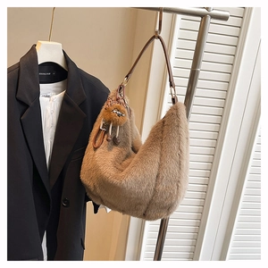 Vue détaillée d'un sac hobo en fausse fourrure marron avec un joli pompon et nœud léopard